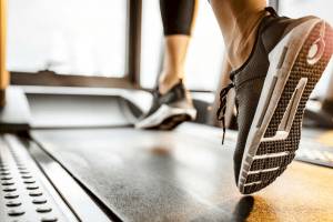 Person, die auf einem Laufband im Fitnessstudio läuft.