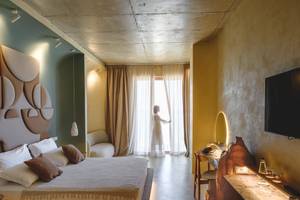 Schlafzimmer im Epidamn White Sensation Hotel mit Bett, Möbeln und Fernseher.