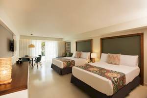 Doppelzimmer im Emotions By Hodelpa Hotel in Puerto Plata mit zwei Betten, Tisch und Stühlen.