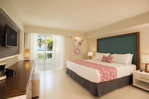 Hotelzimmer im Emotions By Hodelpa Puerto Plata mit Bett, Fernseher und Balkon.