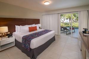 Hotelzimmer im Emotions By Hodelpa Puerto Plata mit Doppelbett, Poolblick und Glastür.