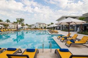 Außenpool des Emotions By Hodelpa Hotels mit gelben Liegestühlen und weißen Sonnenschirmen.