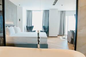 Schlafzimmer im Klajdi Resort & SPA Hotel mit Doppelbett, Badewanne und Meerblick.