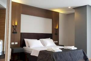 Schlafzimmer im Klajdi Resort & SPA mit einem großen Bett, weißen Kissen und einem Badewanne.