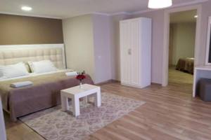 Schlafzimmer im Klajdi Resort & SPA mit einem Bett, Tisch, Vase mit Blumen und Schrank.