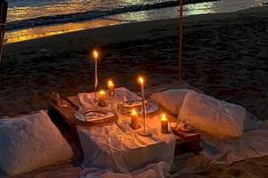 Dinner-Setup am Strand des Klajdi Resort & SPA mit Kerzen und Tischdecken.