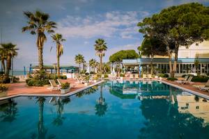 Außenpool des Fafa Beach Hotels mit Loungestühlen und Palmen.