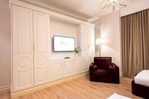 Innenansicht eines Zimmers im Diamma Resort Hotel mit weißem Schrank, Fernseher, Lampe und Bett.