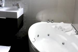Badezimmer mit Badewanne im Demi Hotel