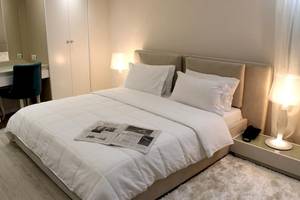 Schlafzimmer im Demi Hotel mit einem Doppelbett, weißen Decken, Kissen und zwei Lampen neben dem Bett.