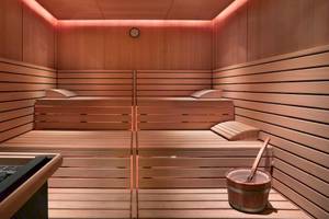 Innenansicht einer Sauna im Grand Hyatt Dubai mit Holzwänden, Liegen und einem Eimer.