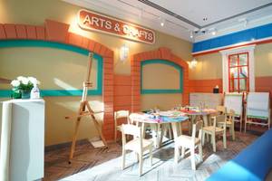 Innenraum des Arts & Crafts Bereichs im Grand Hyatt Dubai mit bunten Wänden und einem Tisch mit Kunstmaterialien.