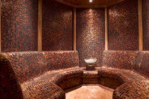 Innenansicht der Sauna im Grand Hyatt Dubai mit gefliesten Wänden und Bänken.