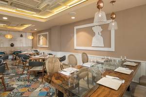 Innenbereich des Restaurants im Emotions By Hodelpa Hotel in Puerto Plata mit Tisch, Stühlen und dekorativen Elementen.