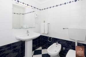 Badezimmer im Ukino Terrace Algarve Hotel mit weißem Waschbecken und Bidet neben einer Toilette.