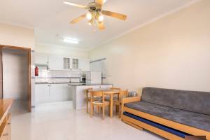 Wohnzimmer im Ukino Terrace Algarve Hotel mit Esstisch, Sofa und offener Küche.