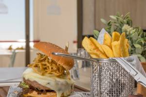 Ein Burger mit Pommes auf einem Tisch im Ukino Terrace Algarve Hotel.