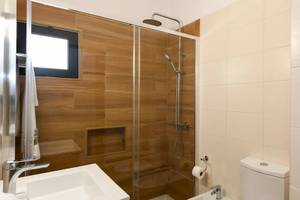 Badezimmer im Pedras da Rainha Resort mit Dusche, Toilette und Waschbecken.