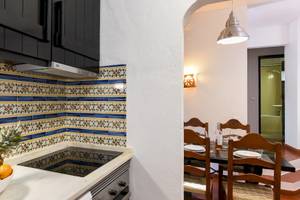 Küche im Pedras da Rainha Resort mit Obstschale, gefliester Wand und Esstisch