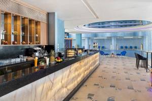 Rezeption im Pickalbatros Blu Spa Resort mit moderner Einrichtung, Marmortheke und blauen Stühlen.