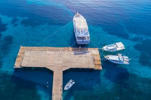 Luftaufnahme der Amwaj Beach Club Anlegestelle mit verankerten Booten im blauen Wasser