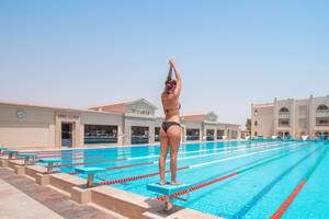 Eine Frau steht auf einem Sprungbrett im olympischen Schwimmbecken des Pickalbatros Aqua Vista Resorts.