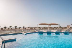 Außenpool des Pickalbatros Aqua Vista Resort mit Sonnenschirm und Blick auf Palmen und Meer.