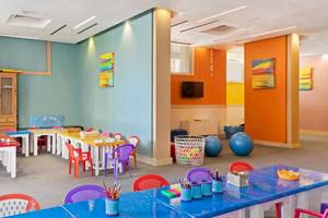 Kinderzimmer im Pickalbatros Aqua Vista Resort mit bunten Tischen, Stühlen und Spielzeug.