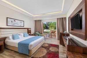 Hotelzimmer im Pickalbatros Aqua Vista Resort mit Bett, Fernseher und Blick auf die Terrasse.