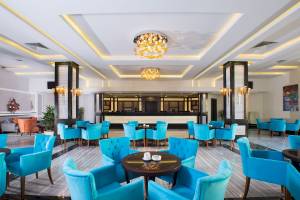 Lobby des Pickalbatros Aqua Vista Resorts mit blauen Stühlen und runden Tischen.