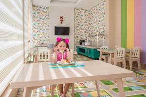 Kleines Mädchen isst Nudeln im Pickalbatros Aqua Vista Resort Kinderzimmer.