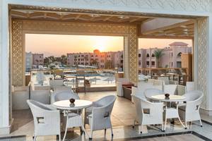 Terrasse des Pickalbatros Aqua Vista Resorts mit Blick auf den Sonnenuntergang und den Pool.