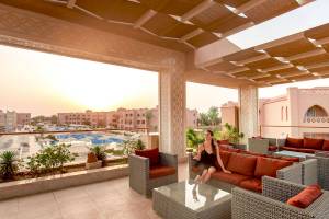 Frau auf der Terrasse des Pickalbatros Aqua Vista Resorts mit Blick auf den Swimmingpool