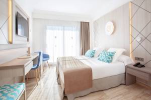 Hotelzimmer von Grupotel Los Principes & Spa mit zwei Betten, Schreibtisch und modernen Möbeln.