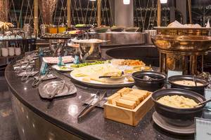 Buffettisch im Chatrium Hotel Riverside Bangkok mit verschiedenen Speisen und Gerichten.