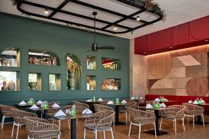 Innenbereich eines Restaurants im RIU Palace Macao mit grünen Wänden, Holztischen und Stühlen.