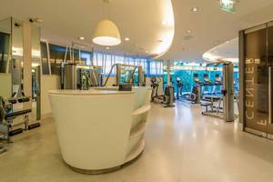 Fitnesscenter im Chatrium Hotel Riverside Bangkok mit modernen Geräten und hellem Ambiente.