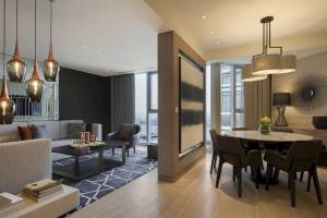 Wohnbereich des Al Bandar Rotana Hotels mit Couch, Tisch und Esstisch