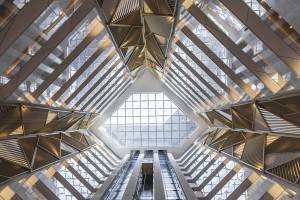 Innenansicht des Al Bandar Rotana Hotels mit Glasdach und geometrischen Mustern.