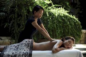 Eine Frau im Hard Rock Hotel Ibiza erhält eine Massage im Freien von einer Therapeutin.