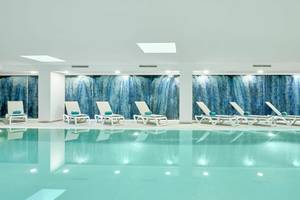 Innenpool im Iberostar Cristina Hotel mit weißen Liegen und blauen Wänden