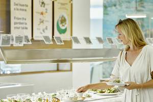 Frau im Restaurant des Iberostar Cristina Hotels, die ein Buffet serviert.