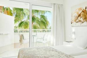 Zimmer im Iberostar Cristina Hotel mit Terrasse und Ausblick auf Palmen und Meer.