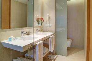 Badezimmer im Hipotels Gran Playa de Palma mit zwei Waschbecken, Handtüchern und Toilette.
