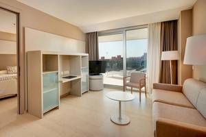 Suite-Zimmer im Hipotels Gran Playa de Palma mit Schlafzimmer, Wohnzimmer und Terrassenblick.