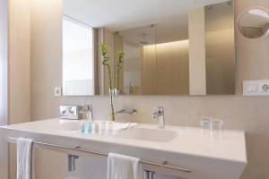 Badezimmer im Hipotels Gran Playa de Palma mit zwei Waschbecken, Spiegeln und Handtüchern.
