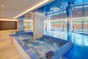Indoor-Poolbereich des Hipotels Gran Playa de Palma mit Whirlpool und blauen Kacheln.