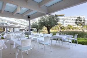 Restaurantterrasse im Hipotels Gran Playa de Palma mit weißen Tischen und Stühlen.