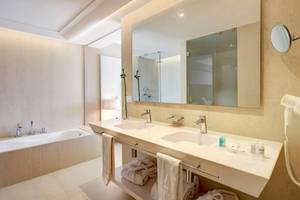 Hotelbadezimmer mit Doppelwaschbecken, Spiegel und Badewanne
