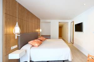 Doppelbett-Zimmer im Iberostar Playa de Muro Hotel mit modernem Design und Holzwand.